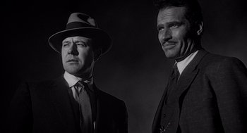 Movie still from “Touch of Evil” (1958), directed by Orson Welles – A black and white photo of two men in suits and hats; Close Up shot, Low angle