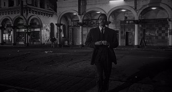 Movie still from “Touch of Evil” (1958), directed by Orson Welles – A black and white photo of a man in a suit and tie; Wide shot, Low angle