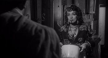 Movie still from “Touch of Evil” (1958), directed by Orson Welles – A black and white photo of a woman holding a pot; Close Up shot, Over the shoulder angle