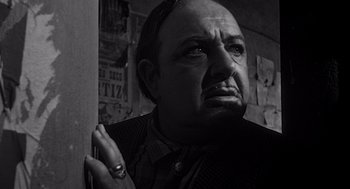 Movie still from “Touch of Evil” (1958), directed by Orson Welles – A man with a beard and a ring in his hand; Close Up shot, Low angle