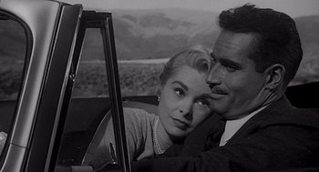 Movie still from “Touch of Evil” (1958), directed by Orson Welles – A man and a woman sitting in the driver's seat of a car; Close Up shot, Over the shoulder angle