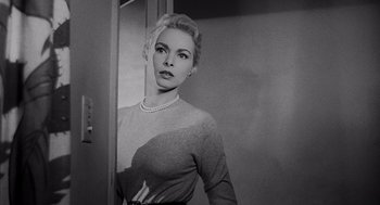 Movie still from “Touch of Evil” (1958), directed by Orson Welles – A black - and - white photo of a woman standing in front of a mirror; Close Up shot, Low angle