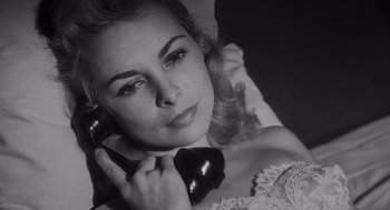 Movie still from “Touch of Evil” (1958), directed by Orson Welles – A beautiful woman holding a phone up to her ear; Close Up shot, High angle