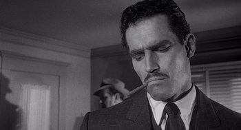 Movie still from “Touch of Evil” (1958), directed by Orson Welles – A black and white photo of a man smoking a pipe; Close Up shot, Low angle