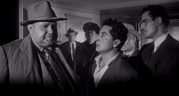 Movie still from “Touch of Evil” (1958), directed by Orson Welles – A black and white photo of a group of men in suits and hats; Medium shot, Low angle