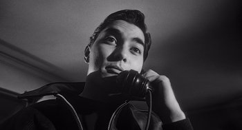 Movie still from “Touch of Evil” (1958), directed by Orson Welles – A black and white photo of a man talking on a phone; Close Up shot, Low angle