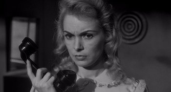 Movie still from “Touch of Evil” (1958), directed by Orson Welles – A black and white photo of a woman holding a camera; Close Up shot, Low angle