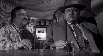 Movie still from “Touch of Evil” (1958), directed by Orson Welles – Two men sitting at a table in a restaurant; Medium shot, Over the shoulder angle