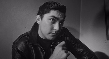 Movie still from “Touch of Evil” (1958), directed by Orson Welles – Black and white photograph of a man in a leather jacket; Close Up shot, Low angle