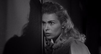 Movie still from “Touch of Evil” (1958), directed by Orson Welles – A black - and - white photo of a woman looking at a mirror; Close Up shot, Low angle