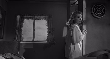 Movie still from “Touch of Evil” (1958), directed by Orson Welles – A black - and - white photo of a woman looking in a mirror; Medium shot, Low angle