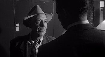 Movie still from “Touch of Evil” (1958), directed by Orson Welles – An older man wearing a hat looking in the mirror; Close Up shot, Over the shoulder angle