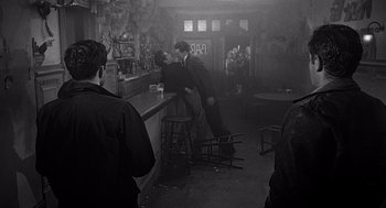 Movie still from “Touch of Evil” (1958), directed by Orson Welles – A man and a woman are kissing in a bar; Wide shot, Over the shoulder angle