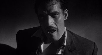 Movie still from “Touch of Evil” (1958), directed by Orson Welles – A black and white photo of a man with a mustache; Close Up shot, Low angle