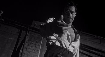 Movie still from “Touch of Evil” (1958), directed by Orson Welles – A black and white photo of a man pointing his finger at the camera; Close Up shot, Low angle