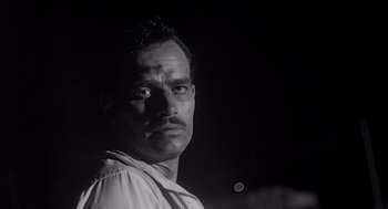 Movie still from “Touch of Evil” (1958), directed by Orson Welles – A black and white photo of a man with a mustache; Close Up shot, Low angle
