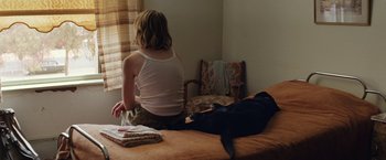 Movie still from “Tracks” (2013), directed by John Curran – A woman sitting on a bed next to a cat; Medium shot, High angle