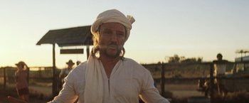 Movie still from “Tracks” (2013), directed by John Curran – A man with a beard wearing a turban and a white shirt; Close Up shot, Over the shoulder angle