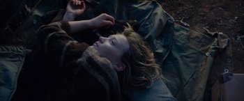 Movie still from “Tracks” (2013), directed by John Curran – A woman laying on the ground in a blanket; Close Up shot, Overhead angle