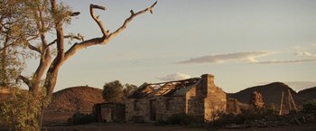 Movie still from “Tracks” (2013), directed by John Curran – An old stone building with a roof that has been torn down; Extreme Wide shot, Low angle