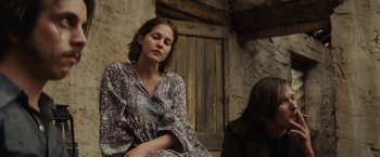 Movie still from “Tracks” (2013), directed by John Curran – A woman sitting on the ground with her hands on her knees; Medium shot, Low angle