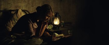 Movie still from “Tracks” (2013), directed by John Curran – A woman sitting at a table writing in a notebook; Medium shot, High angle