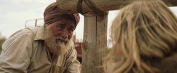 Movie still from “Tracks” (2013), directed by John Curran – An old man with a beard and a turban is sitting next to a woman; Close Up shot, Over the shoulder angle