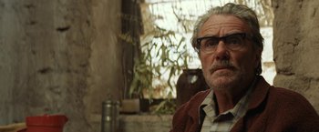 Movie still from “Tracks” (2013), directed by John Curran – An older man wearing glasses looking at the camera; Close Up shot, Low angle