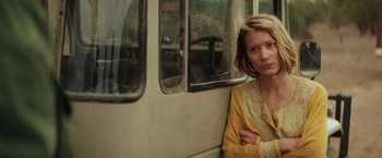 Movie still from “Tracks” (2013), directed by John Curran – A woman sitting on a bus with her arms crossed; Close Up shot, Low angle