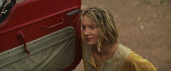 Movie still from “Tracks” (2013), directed by John Curran – A woman leaning against a door of a red vehicle; Close Up shot, Low angle