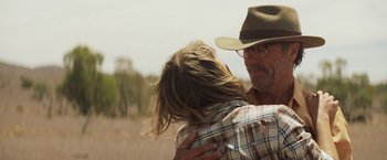 Movie still from “Tracks” (2013), directed by John Curran – A man and a woman hugging in a field; Close Up shot, Over the shoulder angle
