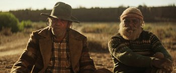 Movie still from “Tracks” (2013), directed by John Curran – A man and a woman sitting on a dirt field; Medium shot, Over the shoulder angle