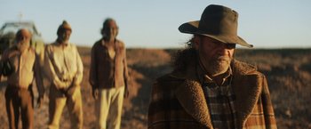 Movie still from “Tracks” (2013), directed by John Curran – A man in a cowboy hat standing next to another man; Medium shot, Over the shoulder angle