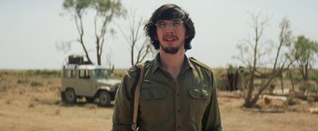 Movie still from “Tracks” (2013), directed by John Curran – A man with a beard wearing glasses and a green shirt; Close Up shot, Over the shoulder angle