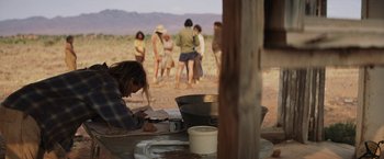 Movie still from “Tracks” (2013), directed by John Curran – A group of people standing in a field; Wide shot, Over the shoulder angle