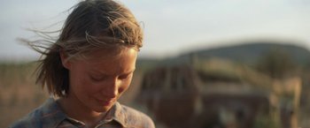 Movie still from “Tracks” (2013), directed by John Curran – A woman's face with a mountain in the background; Close Up shot, Low angle