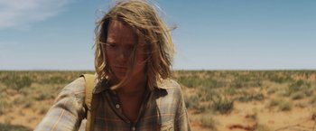 Movie still from “Tracks” (2013), directed by John Curran – A person with long hair standing in the desert; Close Up shot, Low angle