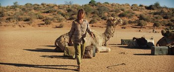 Movie still from “Tracks” (2013), directed by John Curran – A woman walking in the desert with a camel; Wide shot, Low angle
