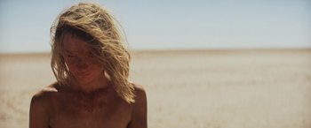 Movie still from “Tracks” (2013), directed by John Curran – A woman standing in the middle of an empty field; Close Up shot, High angle