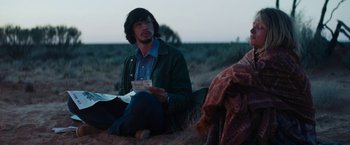 Movie still from “Tracks” (2013), directed by John Curran – A man sitting on the ground holding a piece of paper; Medium shot, Over the shoulder angle