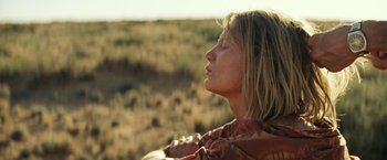 Movie still from “Tracks” (2013), directed by John Curran – A woman with her eyes closed sitting in a field; Close Up shot, Low angle