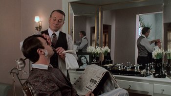 Movie still from “Trading Places” (1983), directed by John Landis – A man getting his hair cut at a barber shop; Close Up shot, Over the shoulder angle