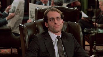 Movie still from “Trading Places” (1983), directed by John Landis – A man in a suit and tie sitting in a leather chair; Close Up shot, Low angle
