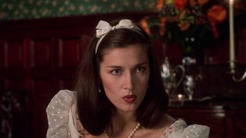 Movie still from “Trading Places” (1983), directed by John Landis – A young woman wearing a white dress with a bow in her hair; Close Up shot, Over the shoulder angle