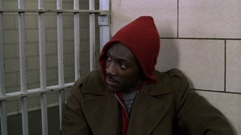 Movie still from “Trading Places” (1983), directed by John Landis – A man in a brown jacket and a red hat; Close Up shot, High angle