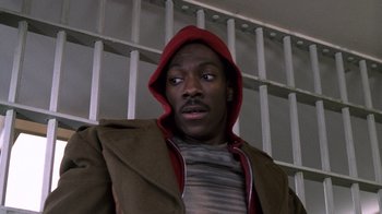 Movie still from “Trading Places” (1983), directed by John Landis – A man in a brown jacket and a red hat; Close Up shot, Low angle
