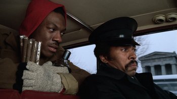 Movie still from “Trading Places” (1983), directed by John Landis – Two men sitting in the back seat of a car; Close Up shot, Low angle