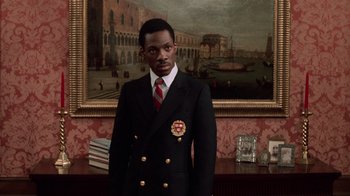 Movie still from “Trading Places” (1983), directed by John Landis – A man in a suit and tie standing in front of a painting; Close Up shot, Low angle