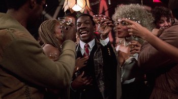 Movie still from “Trading Places” (1983), directed by John Landis – A group of people drinking wine at a party; Medium shot, Over the shoulder angle