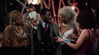 Movie still from “Trading Places” (1983), directed by John Landis – A man and a woman holding money in a crowd of people; Medium shot, Over the shoulder angle